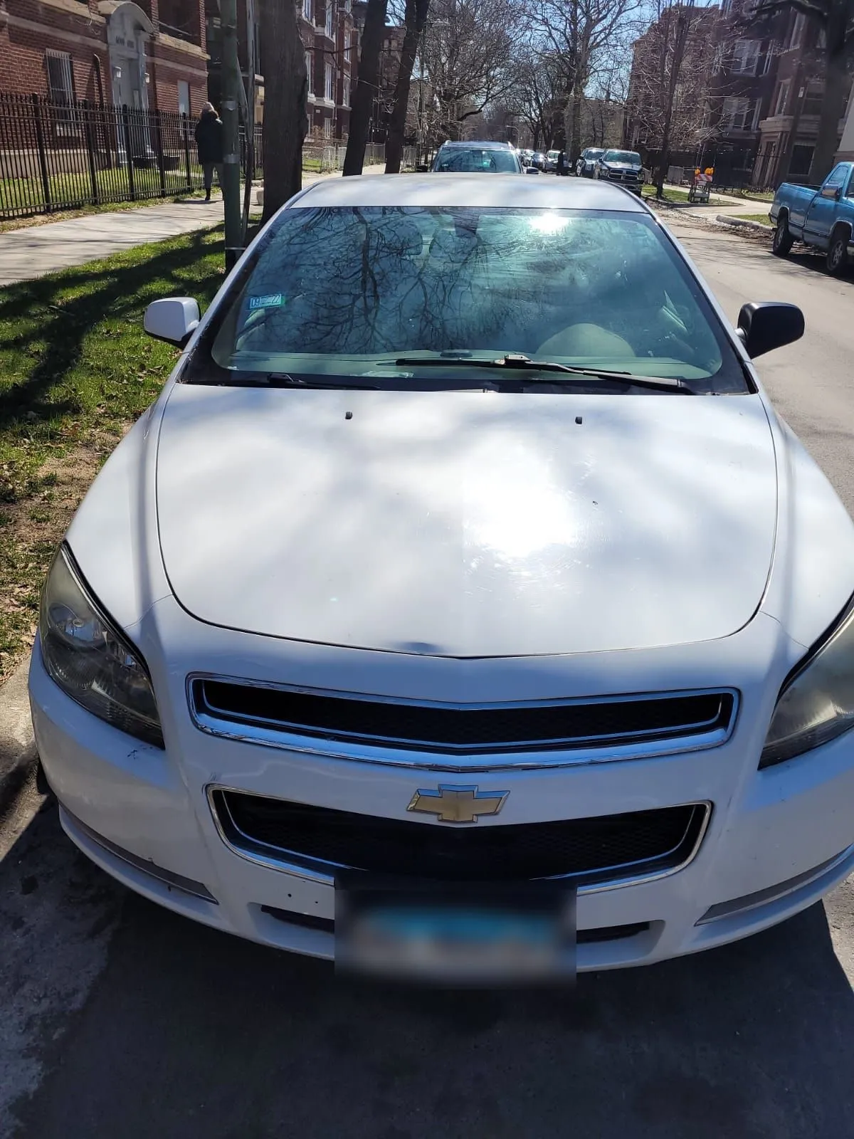 White sedan at the curb, ready for its pickup.